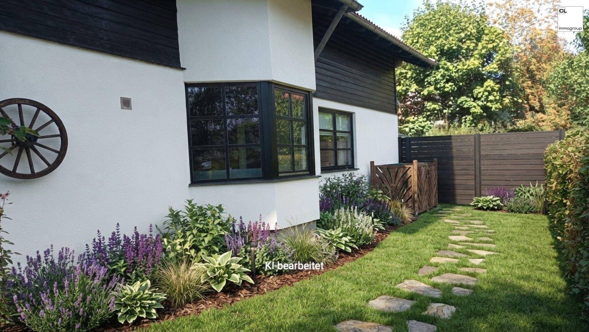 Seitenansicht des Hauses mit gepflegtem Garten, Blumenbeeten und einem Steinpfad.