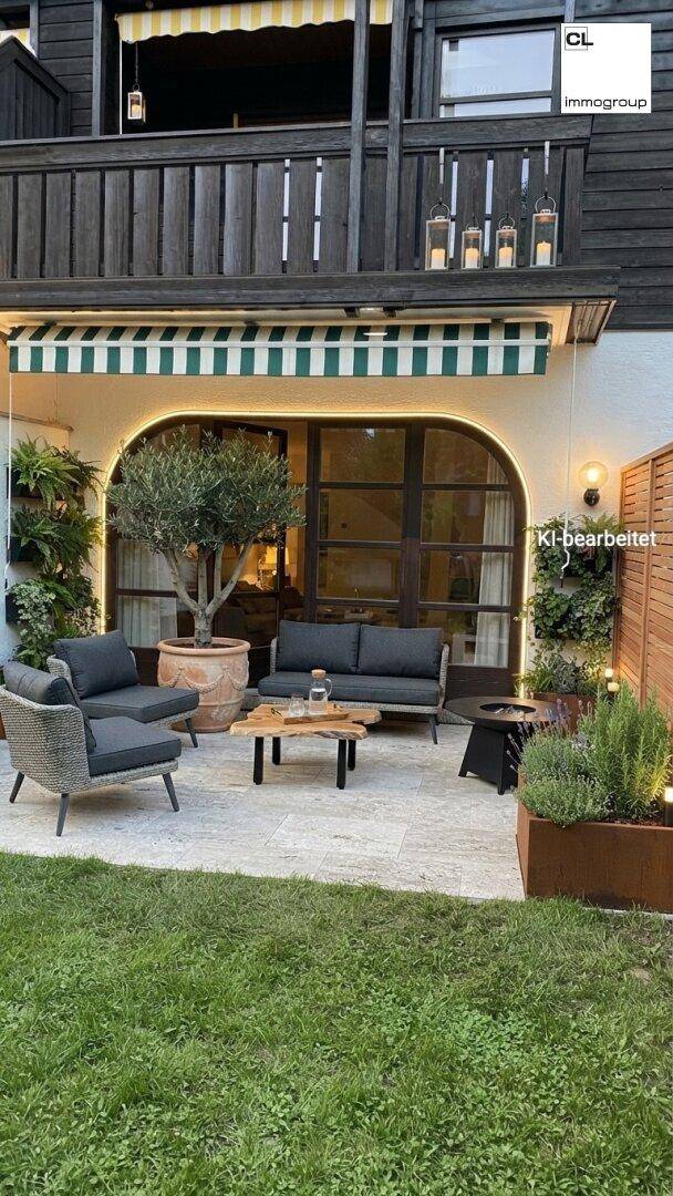 Gemütliche Terrasse mit bequemen Loungemöbeln, einem Olivenbaum und einem Balkon darüber.