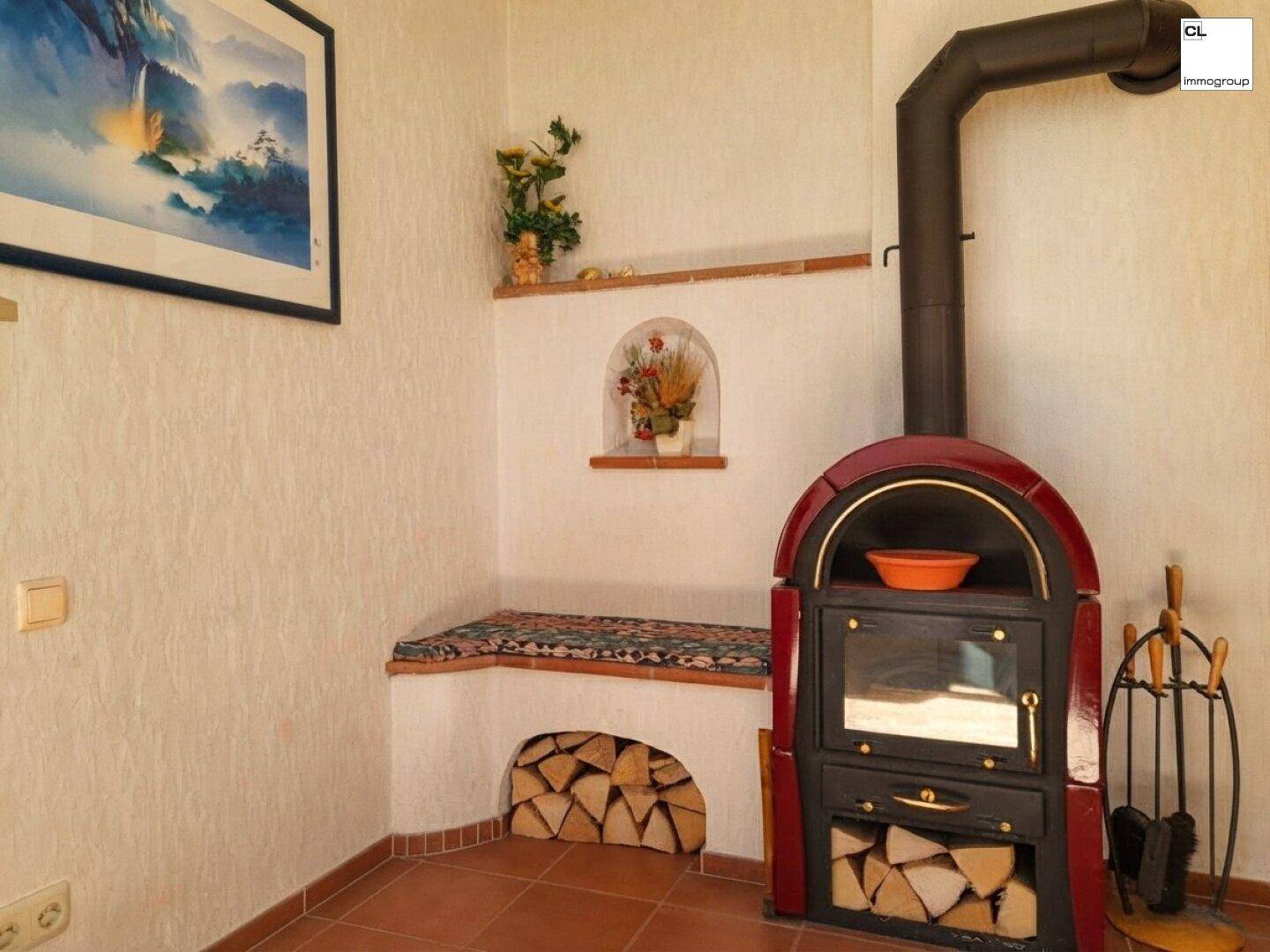 Traditioneller Holzofen mit Kamin und praktischem Holzlager im gemütlichen Wohnbereich.