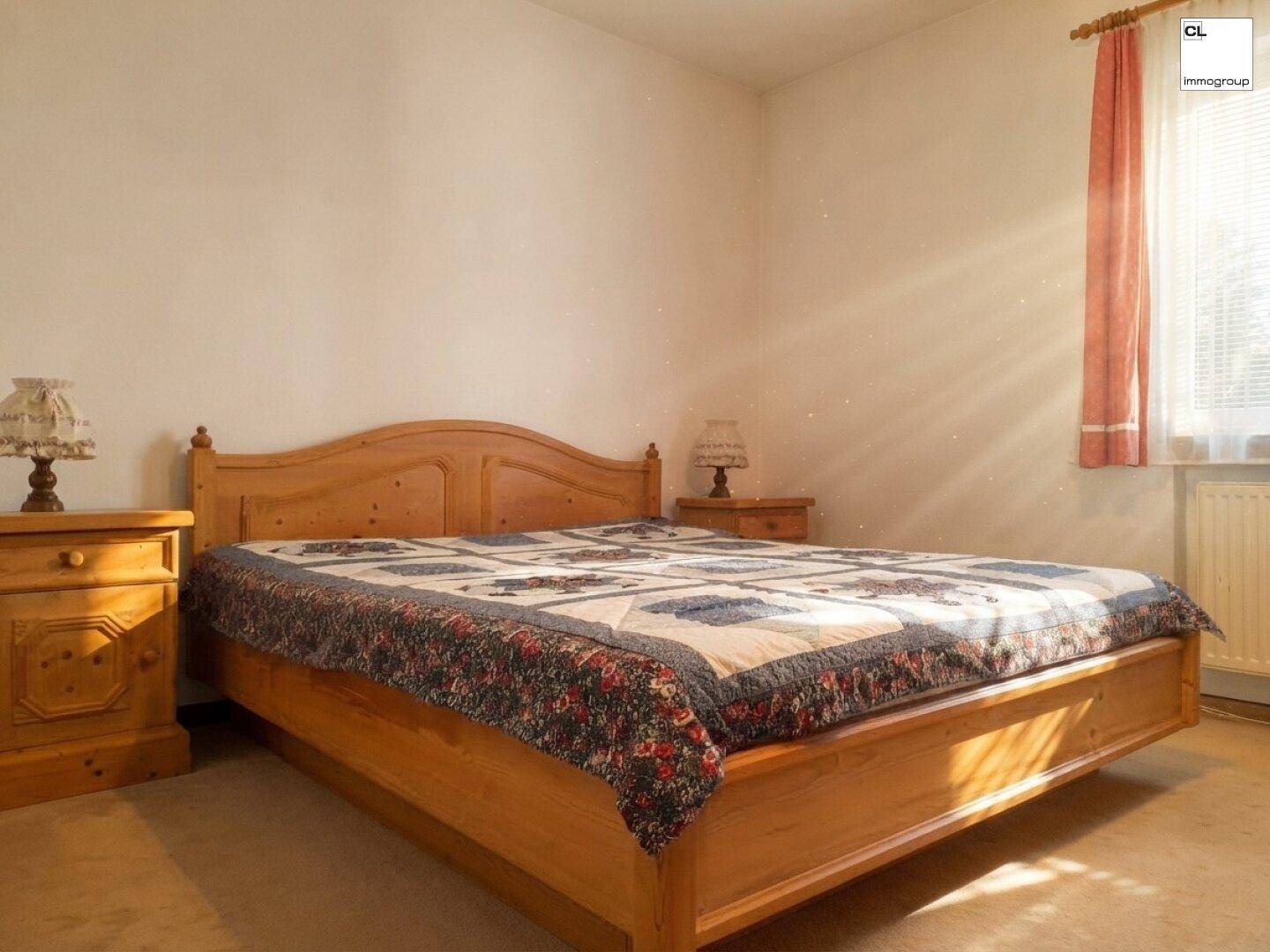 Helles Schlafzimmer mit Doppelbett aus hellem Holz und Teppichboden.