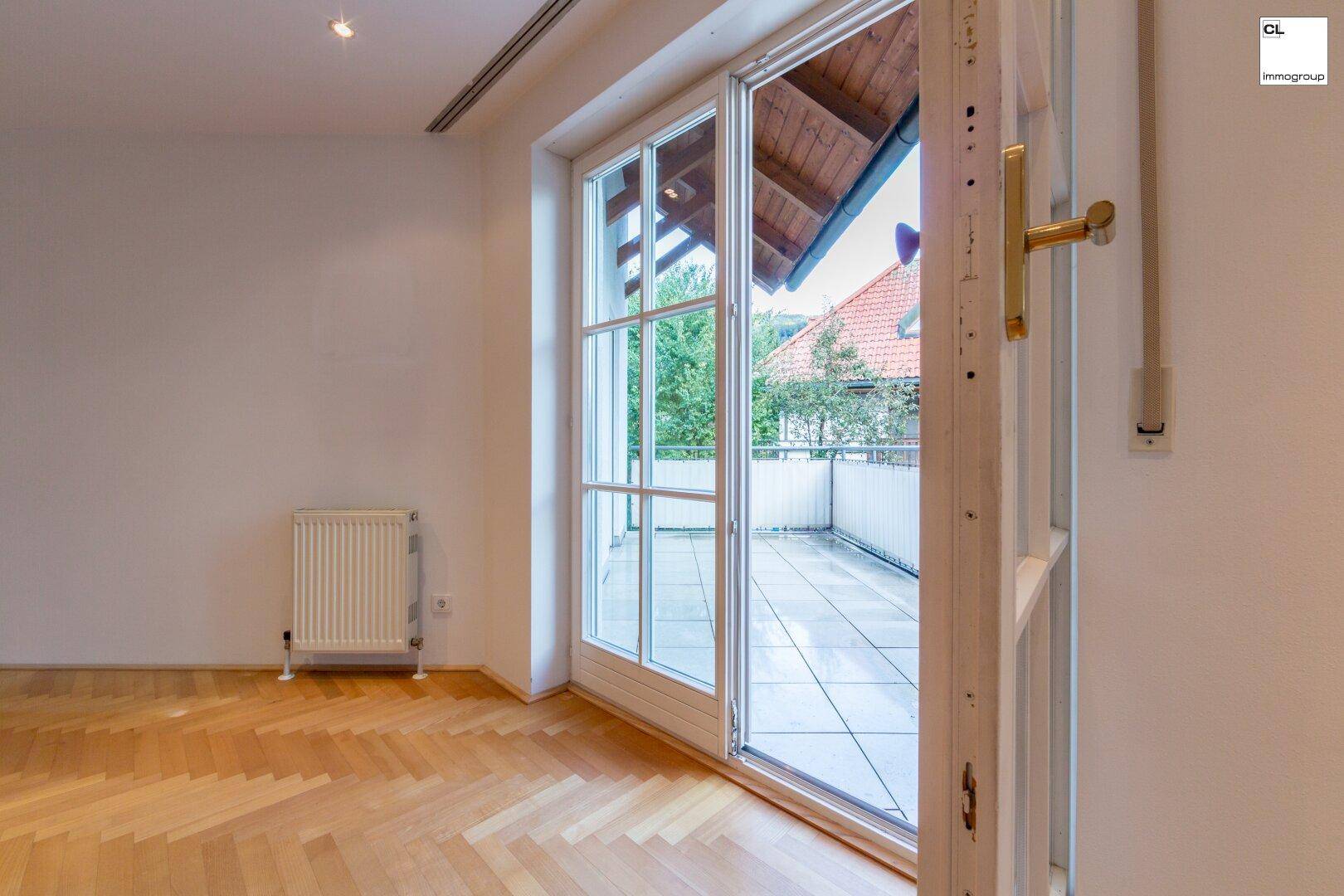 Heller Wohnbereich mit Zugang zu einer Terrasse oder einem Balkon und Holzdachuntersicht.