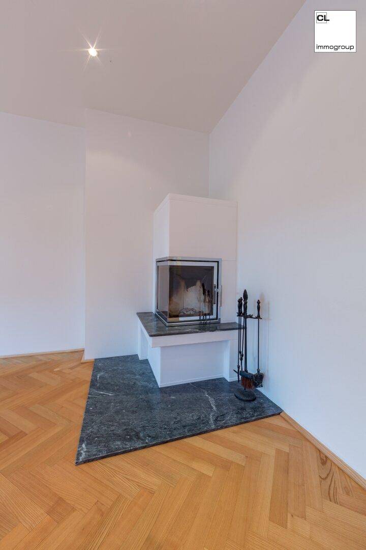 Moderner Kamin mit Marmorplatte und Kaminbesteck in einem hellen Wohnzimmer.
