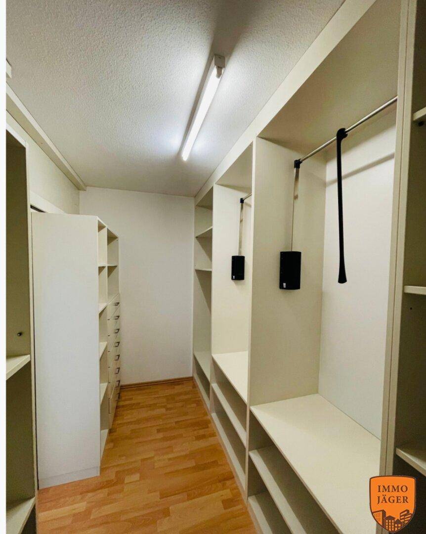 Geräumiger begehbarer Kleiderschrank mit vielen Regalen und Kleiderstangen für Organisation.