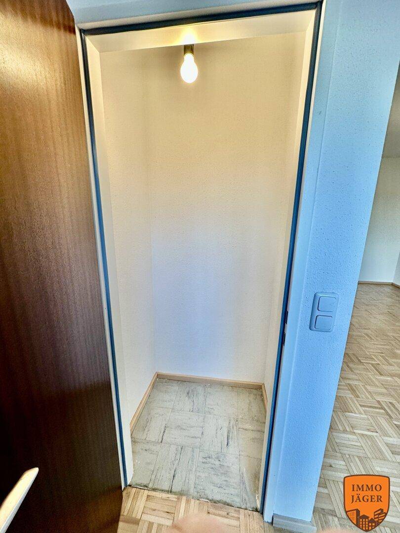 Kleiner Abstellraum oder Nische mit einfacher Beleuchtung und Fliesenboden.