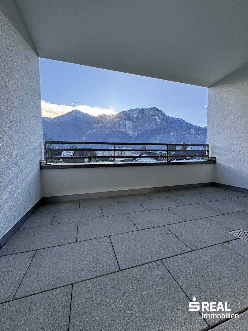 Großer Balkon mit Fliesenboden und weitem Blick auf die Berge und die Umgebung.