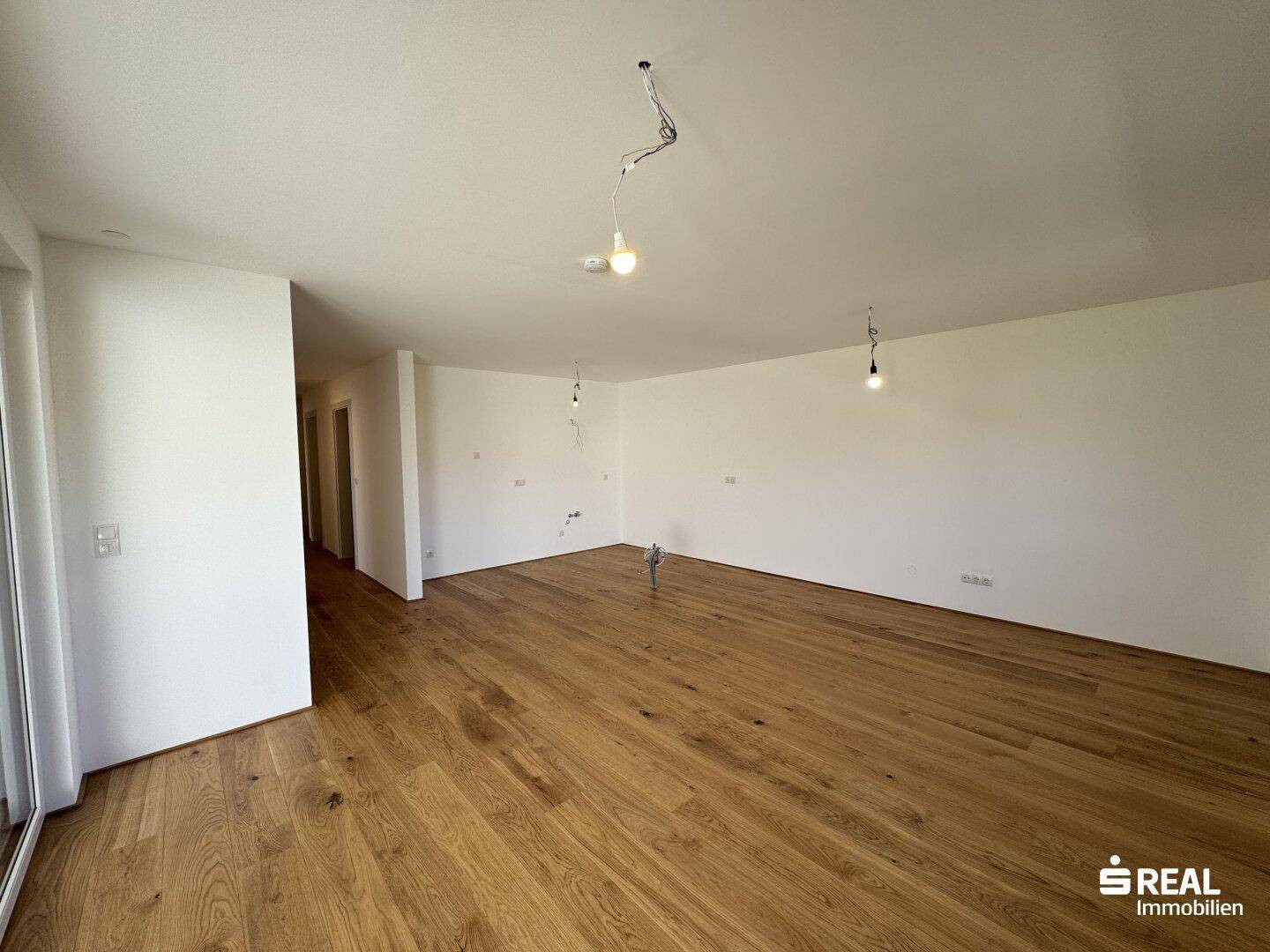 Großzügiger Wohnbereich mit hochwertigem Holzparkett und viel Potenzial für individuelle Gestaltung.