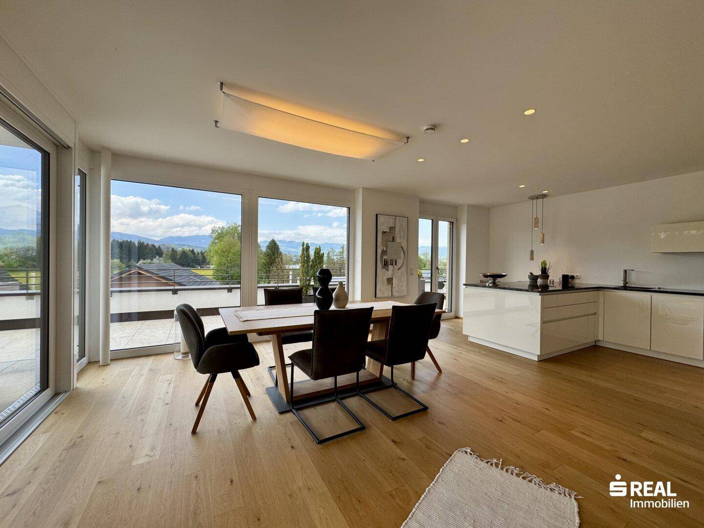 Heller Wohn-Essbereich mit offener Küche, Holzboden und Zugang zur großen Terrasse.