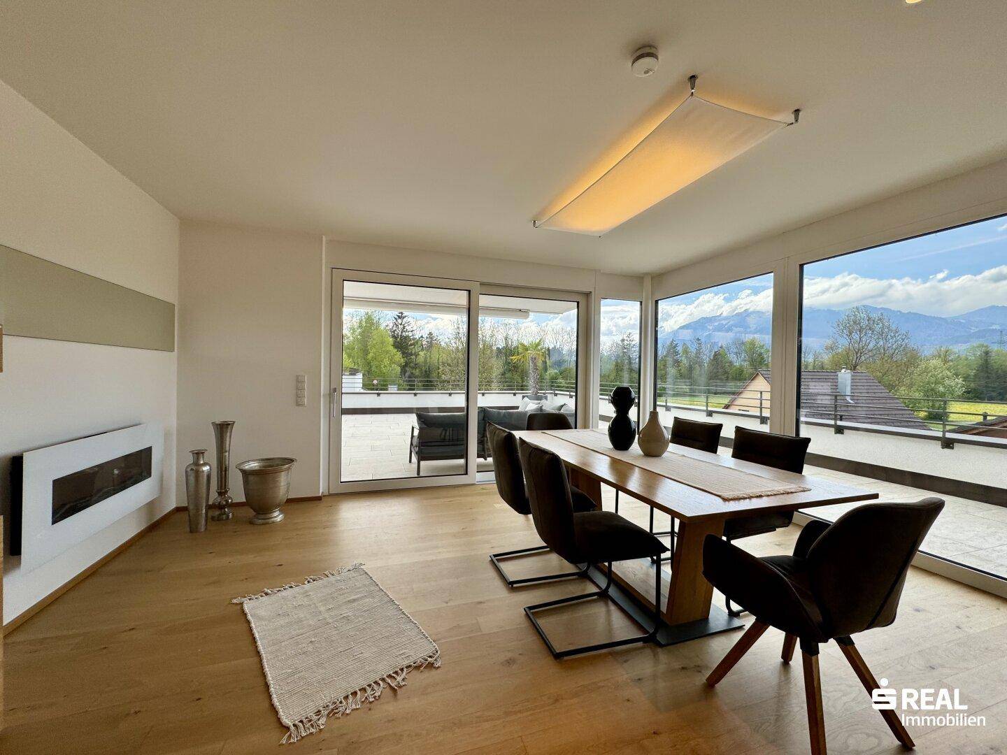 Lichtdurchfluteter Essbereich mit Holztisch, modernen Stühlen und direktem Zugang zur Terrasse.