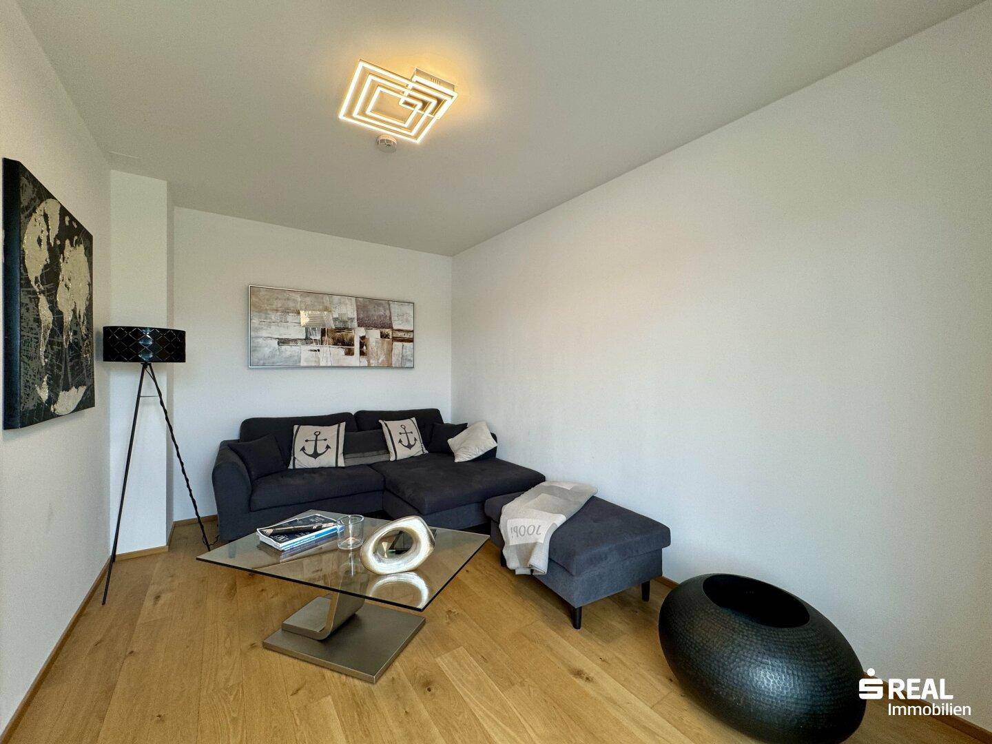 Gemütliches Wohnzimmer mit Sofa, Couchtisch und moderner Dekoration.