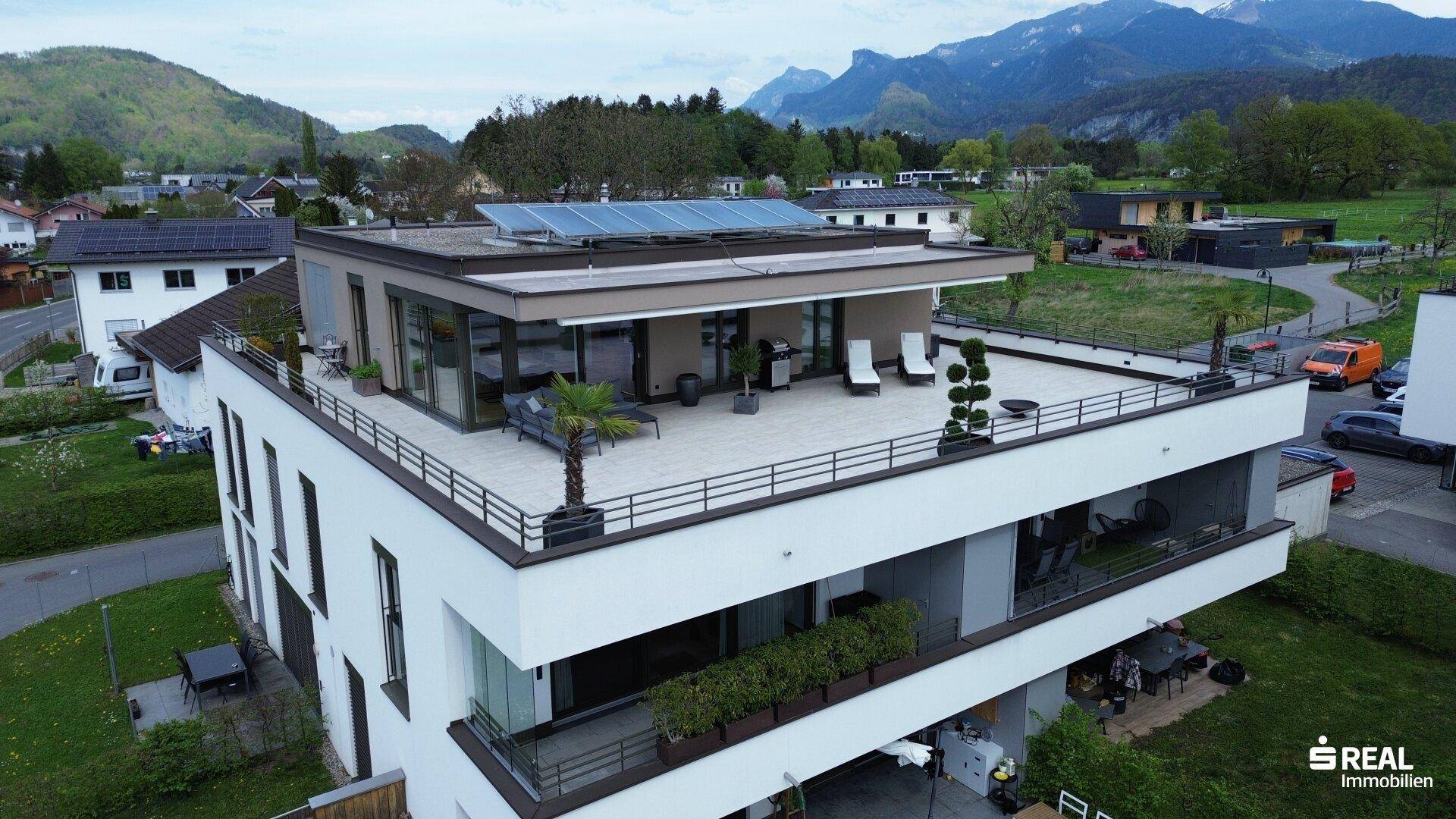 Moderne Wohnanlage mit großzügigen Dachterrassen und Photovoltaikanlage auf dem Flachdach.