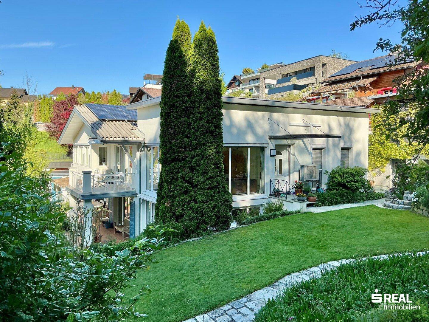 Großzügiges Einfamilienhaus mit gepflegtem Garten, Photovoltaikanlage auf dem Dach und viel Grün.