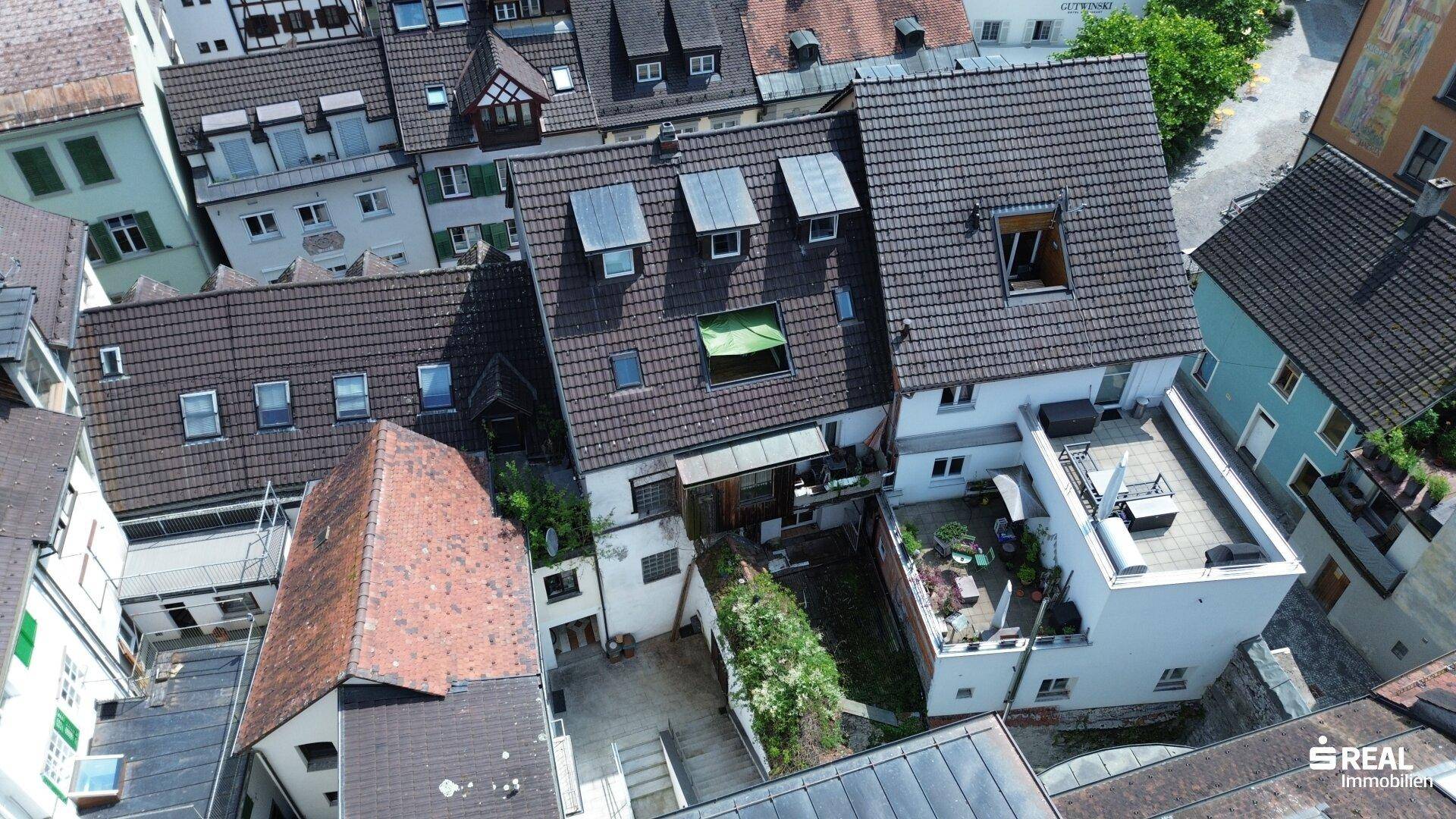 Luftaufnahme einer dicht bebauten Altstadt mit vielen Dächern und Innenhöfen, historisches Stadtbild.