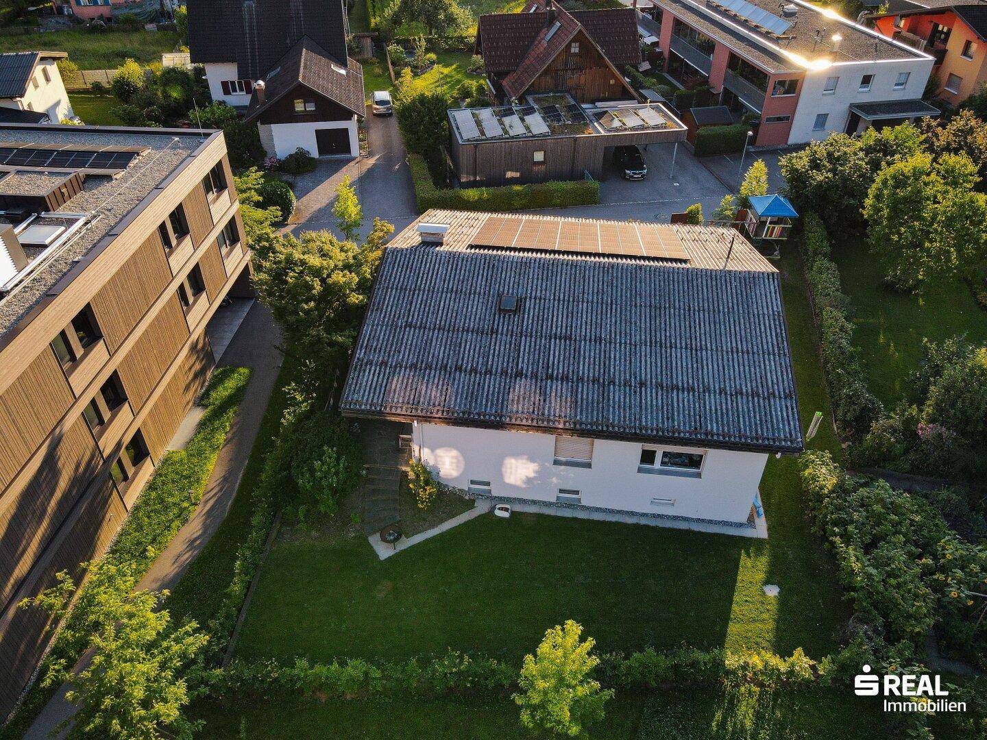 Luftaufnahme des Hauses mit Garten und umliegenden Gebäuden in grüner Umgebung.