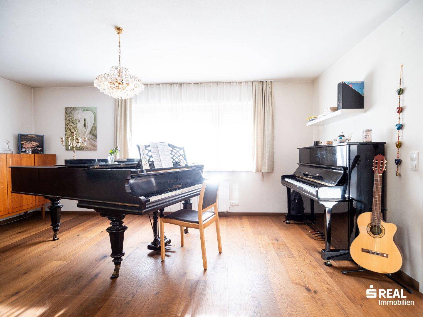 Geräumiges Wohnzimmer mit zwei Klavieren und Gitarre, ideal für Musikliebhaber.