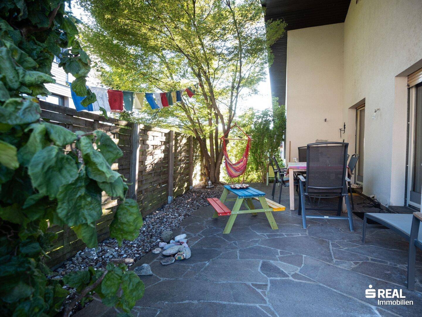 Terrasse mit Sitzgelegenheiten, kleinem Picknicktisch und Feuerstelle im Freien.