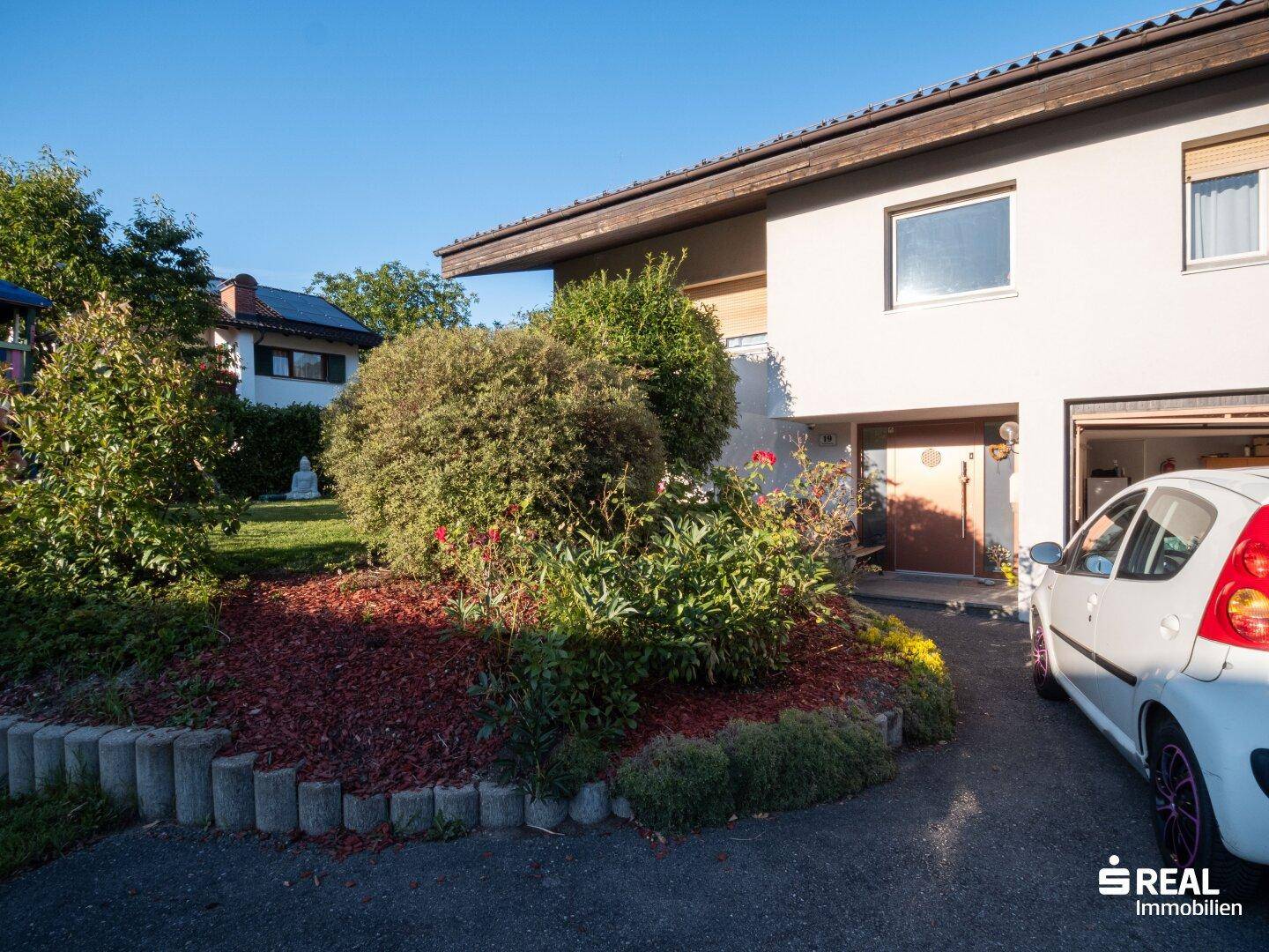 Außenansicht des Hauses mit gepflegtem Vorgarten und einer Einfahrt.
