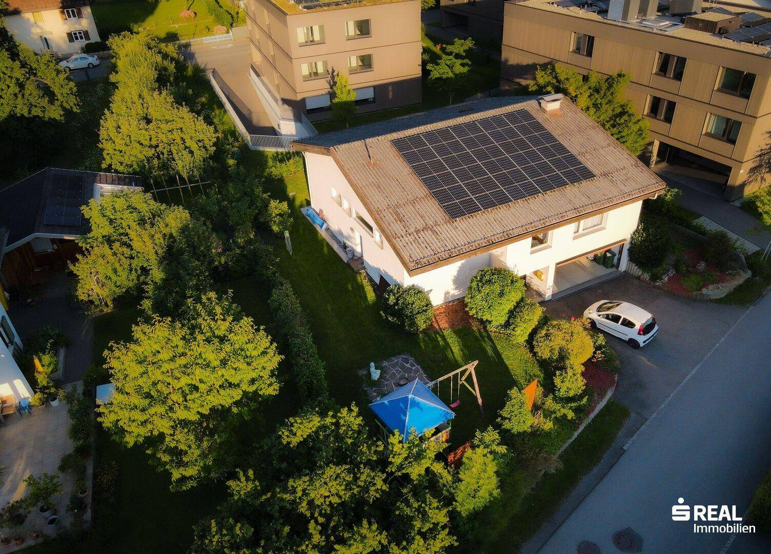 Luftaufnahme des Hauses mit Solaranlage auf dem Dach und großem Garten in der Nachbarschaft.