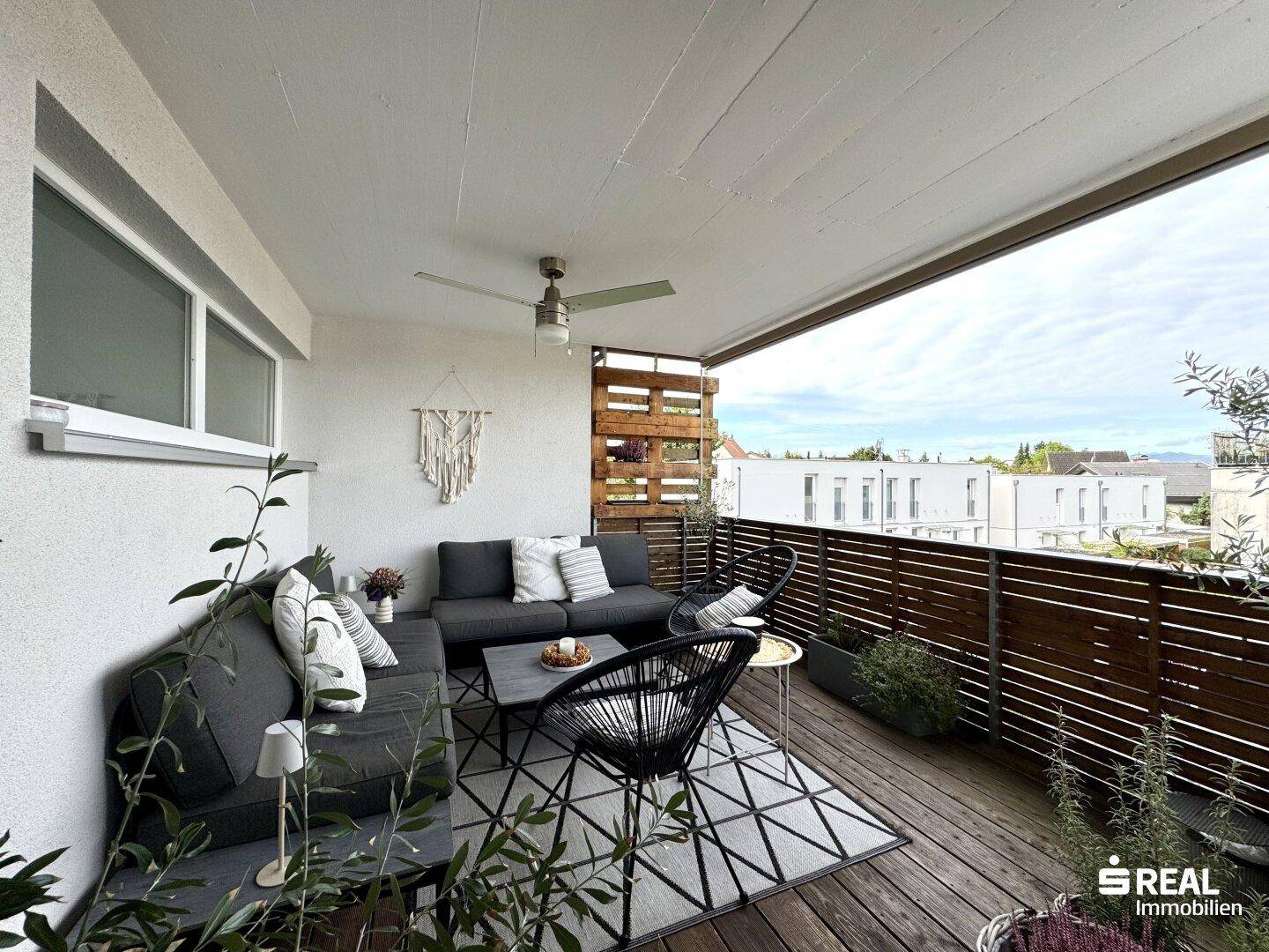 Geräumiger Balkon mit gemütlicher Lounge-Sitzgruppe und Blick auf die Umgebung.
