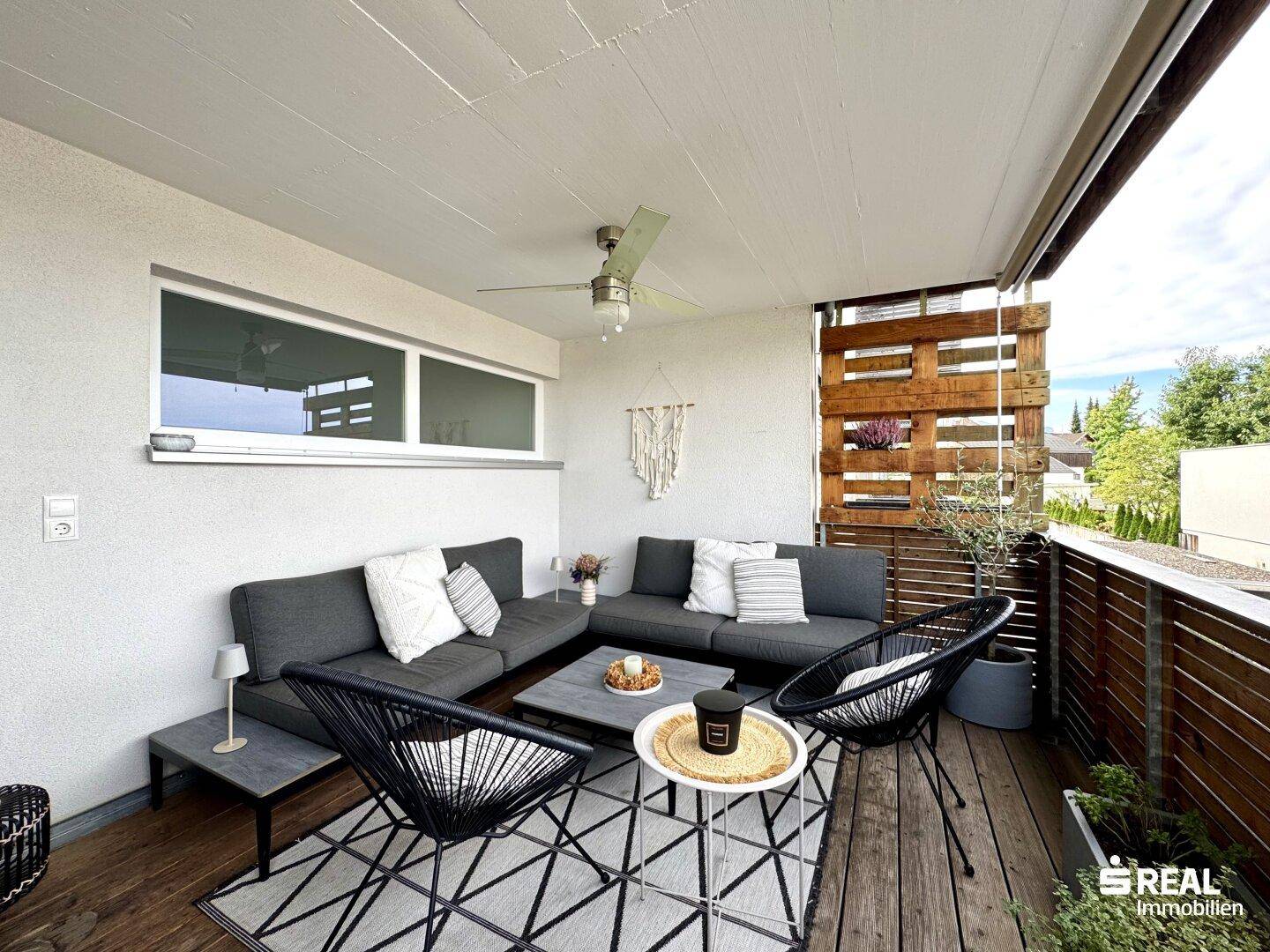 Geräumiger Balkon mit gemütlicher Lounge-Sitzgruppe und Blick auf die Umgebung.