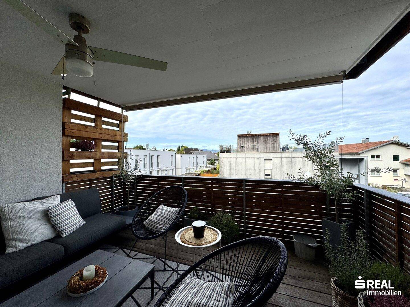 Großer Balkon mit bequemen Möbeln und weitem Blick über die Dächer.