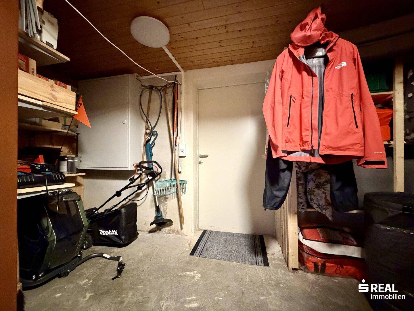 Geräumiger Kellerraum mit Werkzeugen, Gartengeräten und Zugang zu einem weiteren Bereich.