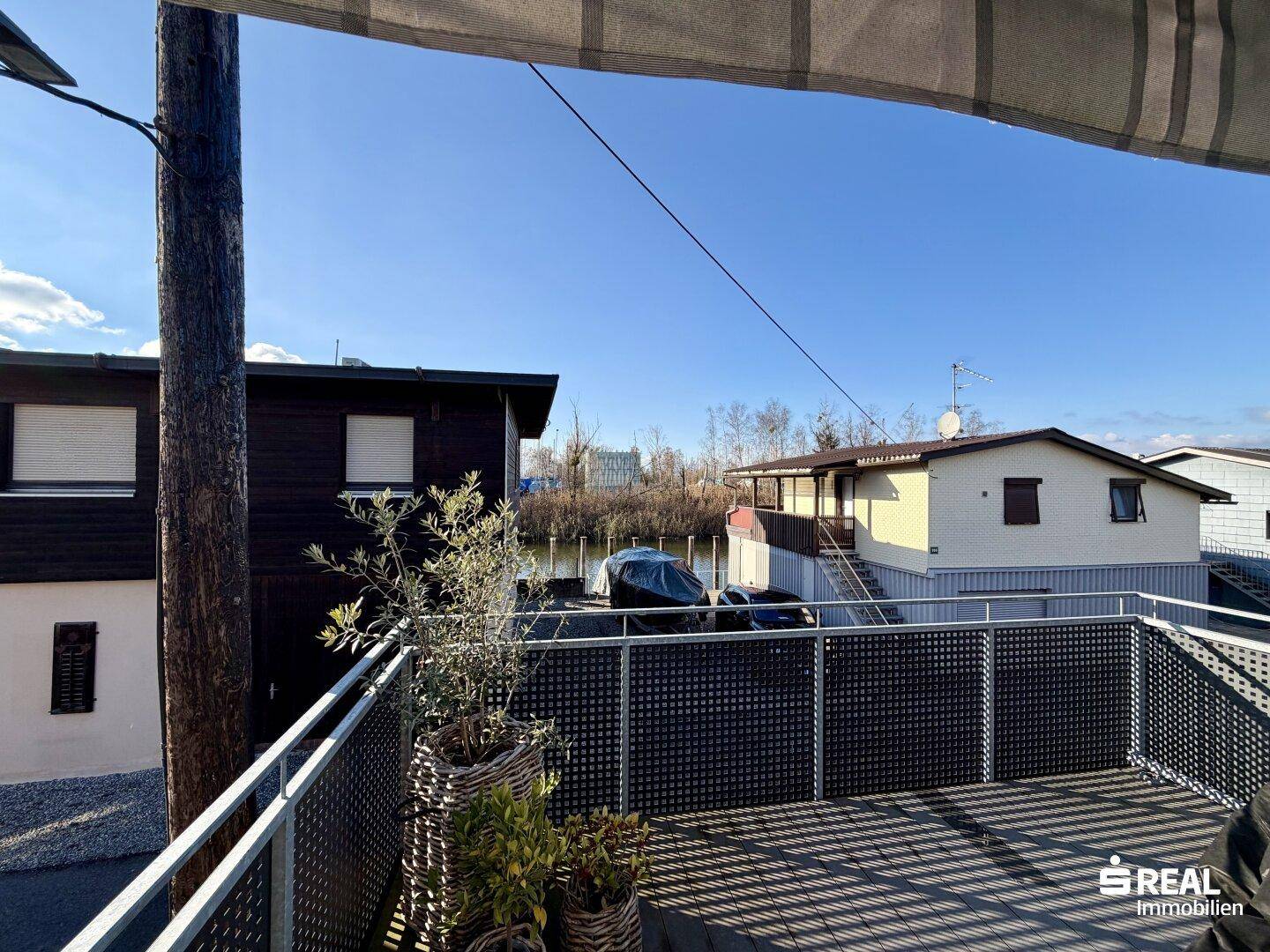 Sonniger Balkon mit Blick auf die Umgebung und das Wasser, ideal zum Entspannen.