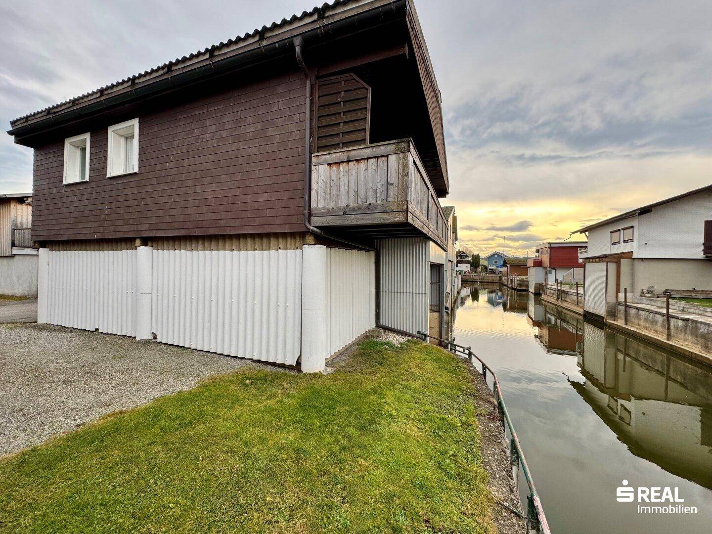 Seitenansicht des Hauses mit Bootsgarage und Zugang zum Kanal.