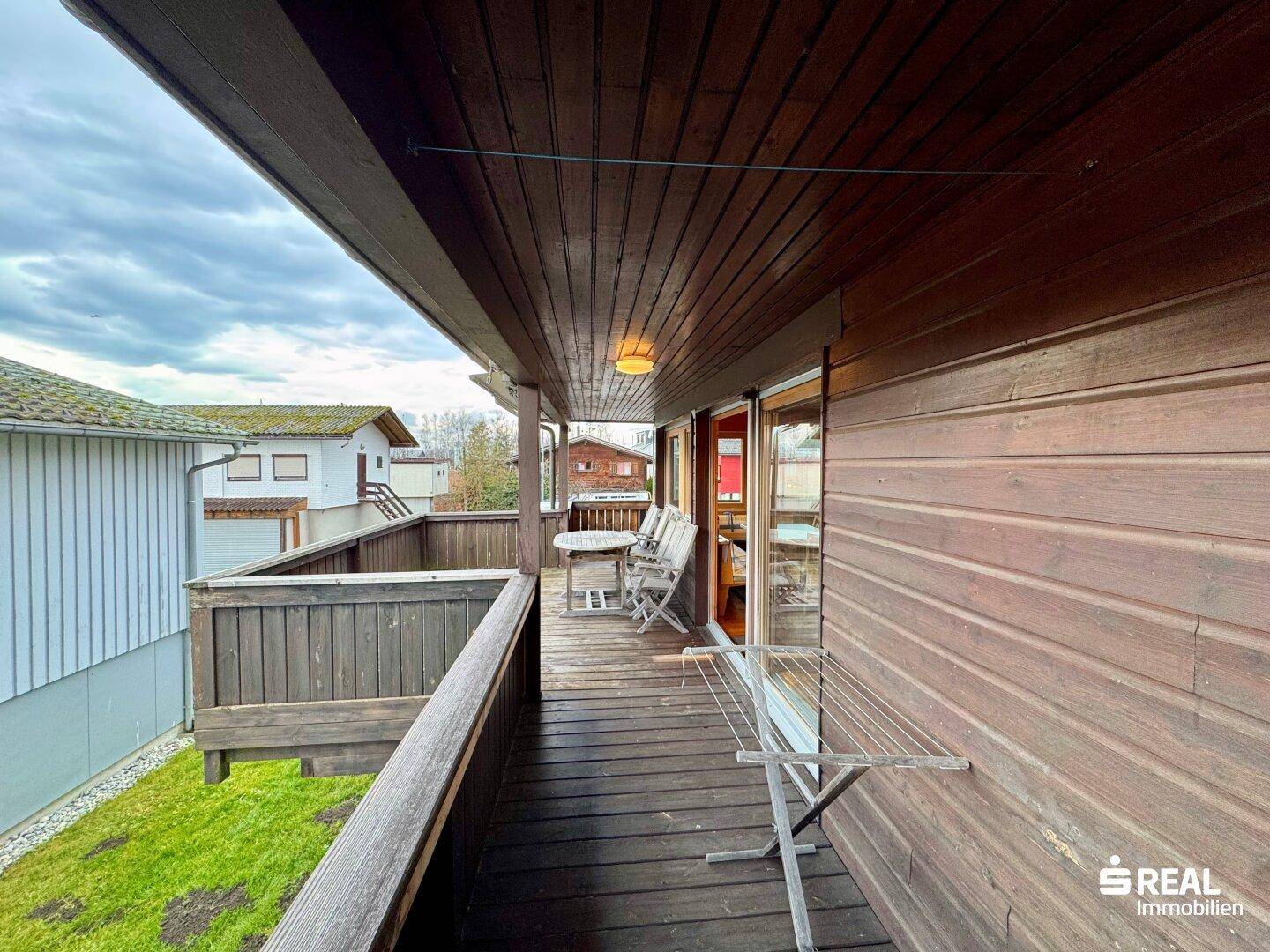 Holzterrasse mit Wäscheständer und Blick auf die Nachbarschaft.
