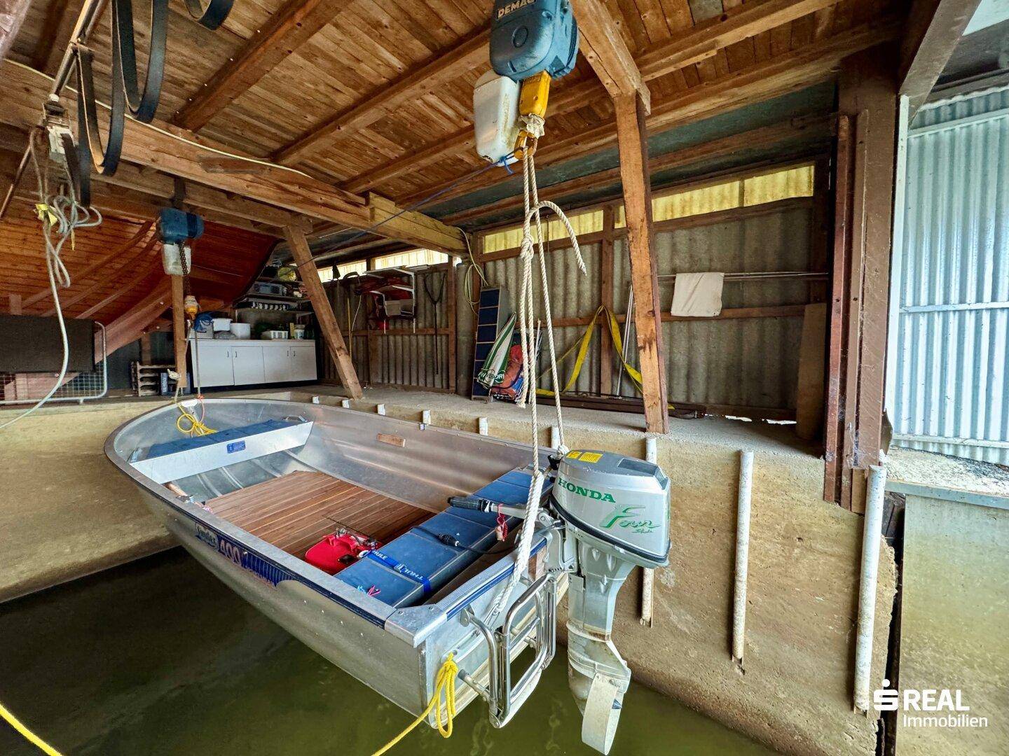 Bootsgarage mit hängendem Motorboot und rustikaler Holzkonstruktion.