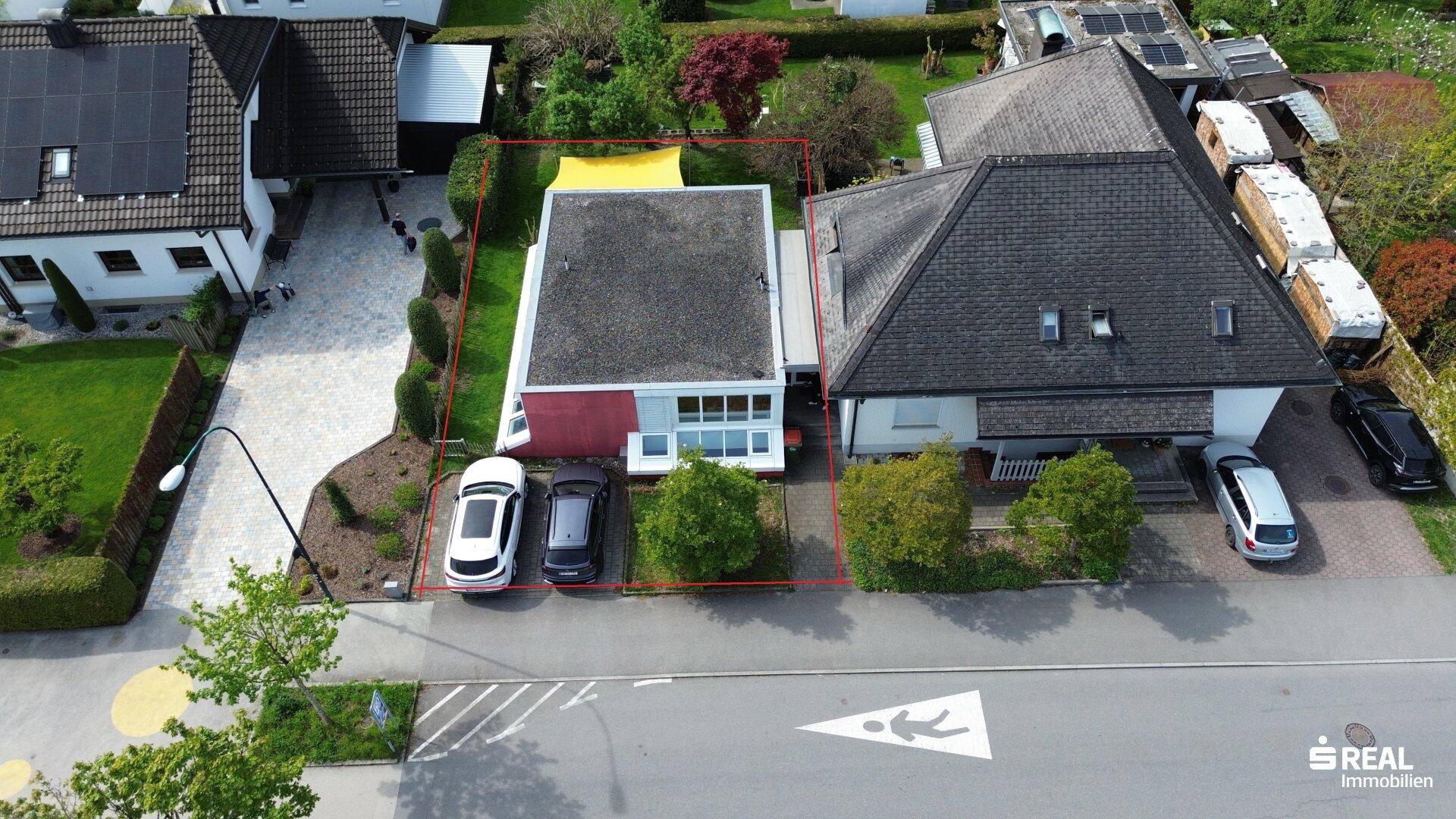 Luftaufnahme des Grundstücks mit umliegenden Häusern und der Straße.
