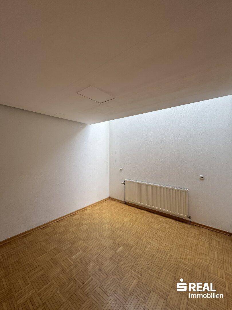 Raum mit Parkettboden und Oberlicht, das zusätzliches Tageslicht spendet.