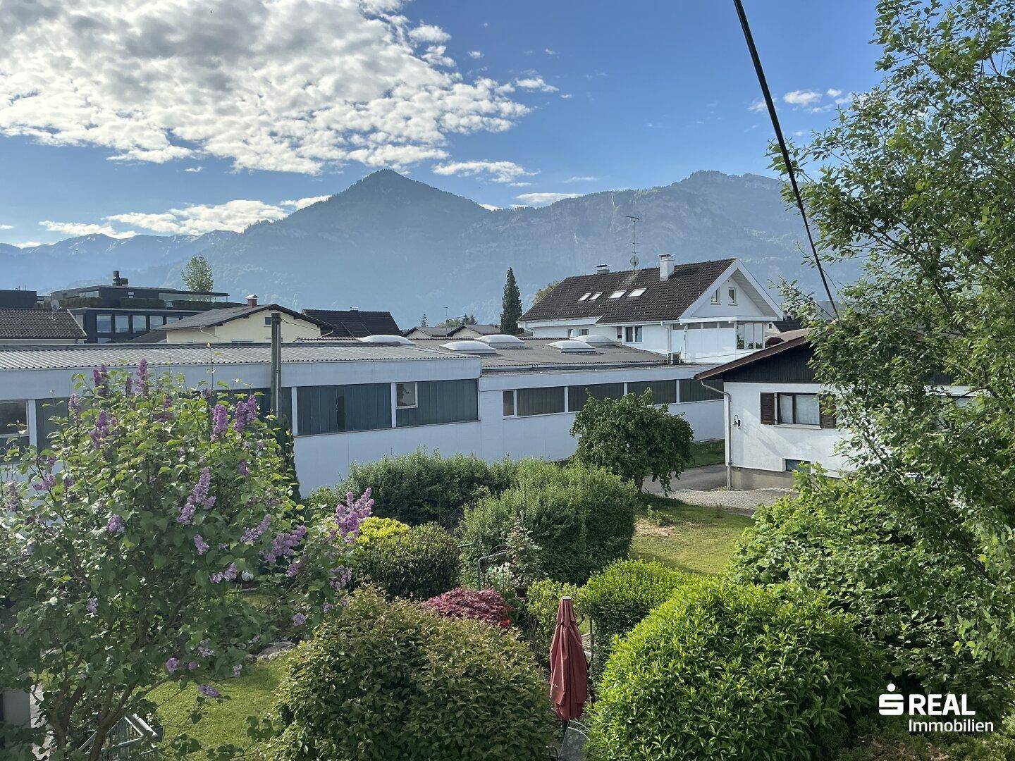 Panoramablick auf die umliegende Berglandschaft und benachbarte Häuser.