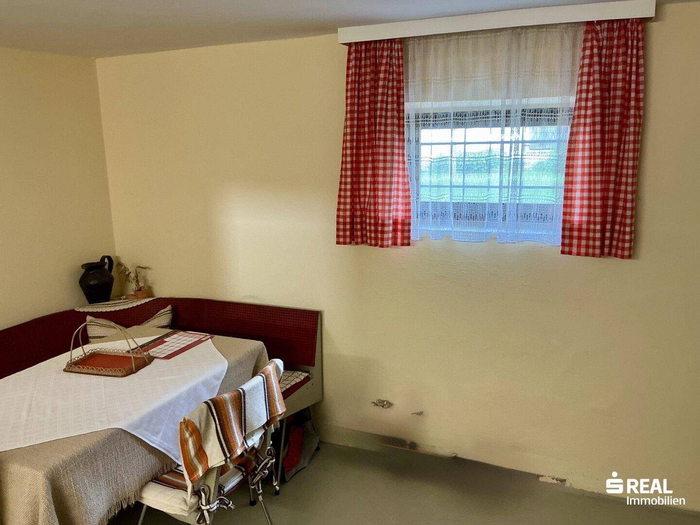 Gemütlicher Raum im Kellergeschoss mit Essbereich und Fenster.