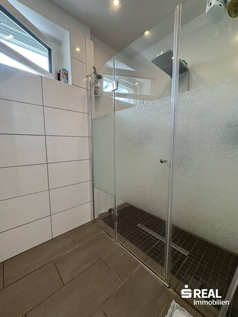 Geräumige Duschkabine mit Glasabtrennung und modernen Fliesen im Badezimmer.