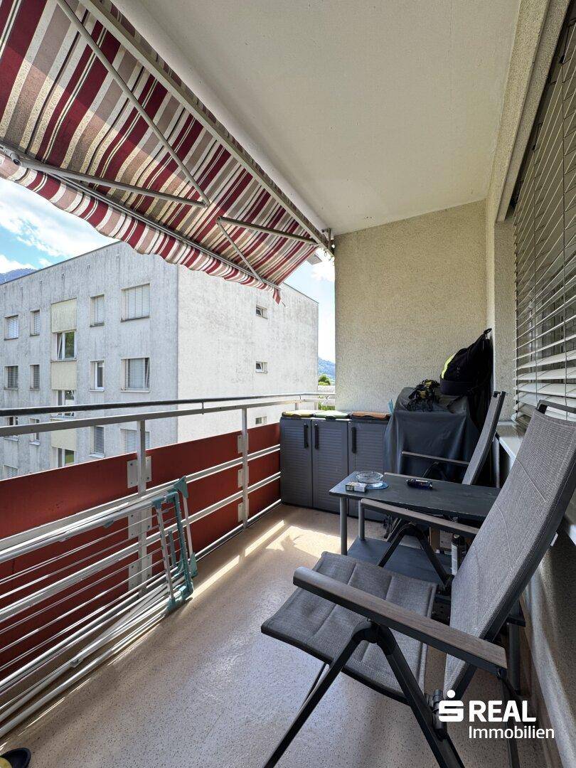 Gemütlicher Balkon mit Markise und Sitzgelegenheiten, ideal zum Entspannen im Freien.