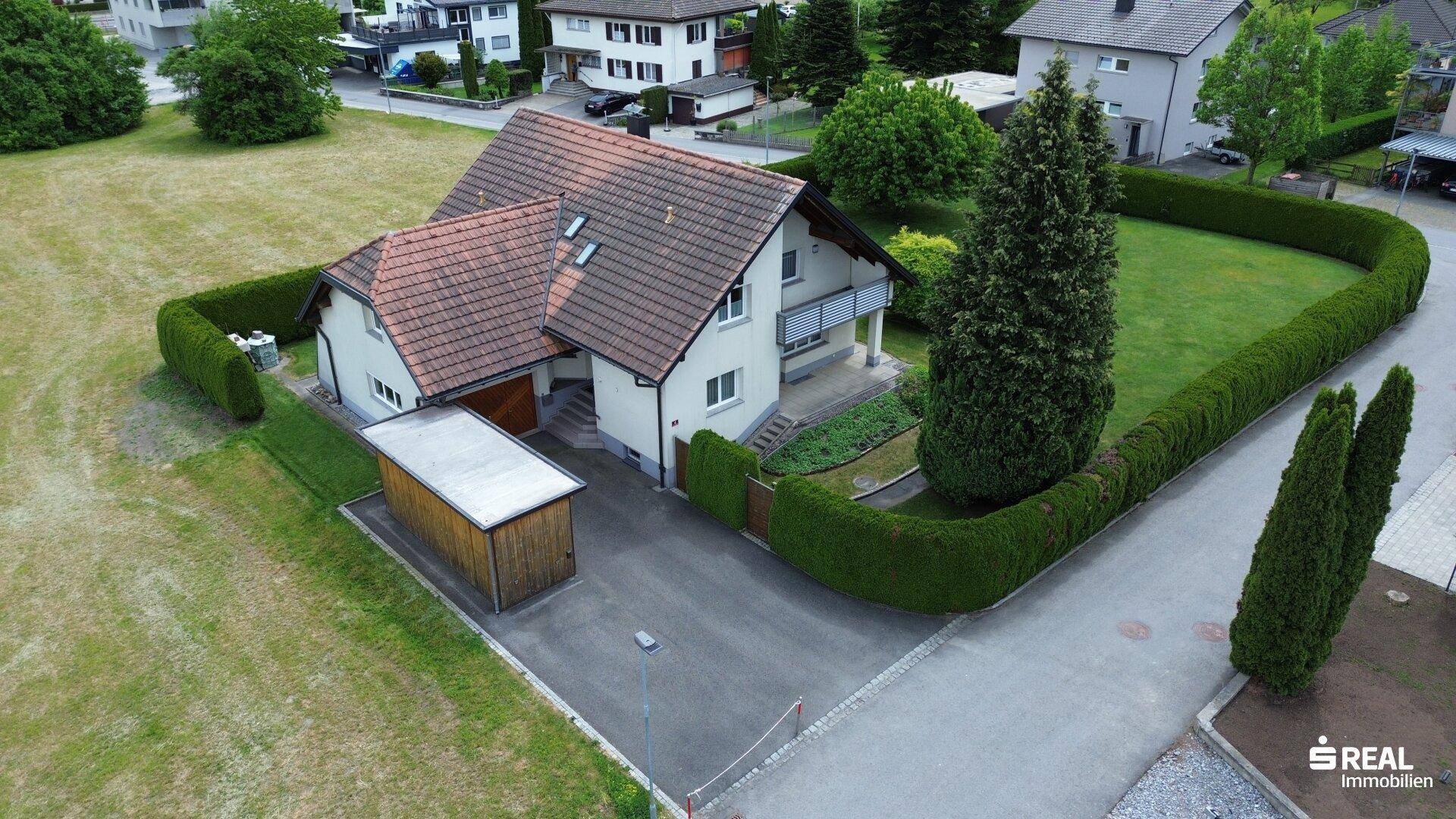 Luftaufnahme des Anwesens mit großem Garten, Carport und gepflegter Außenanlage in ländlicher Umgebung.