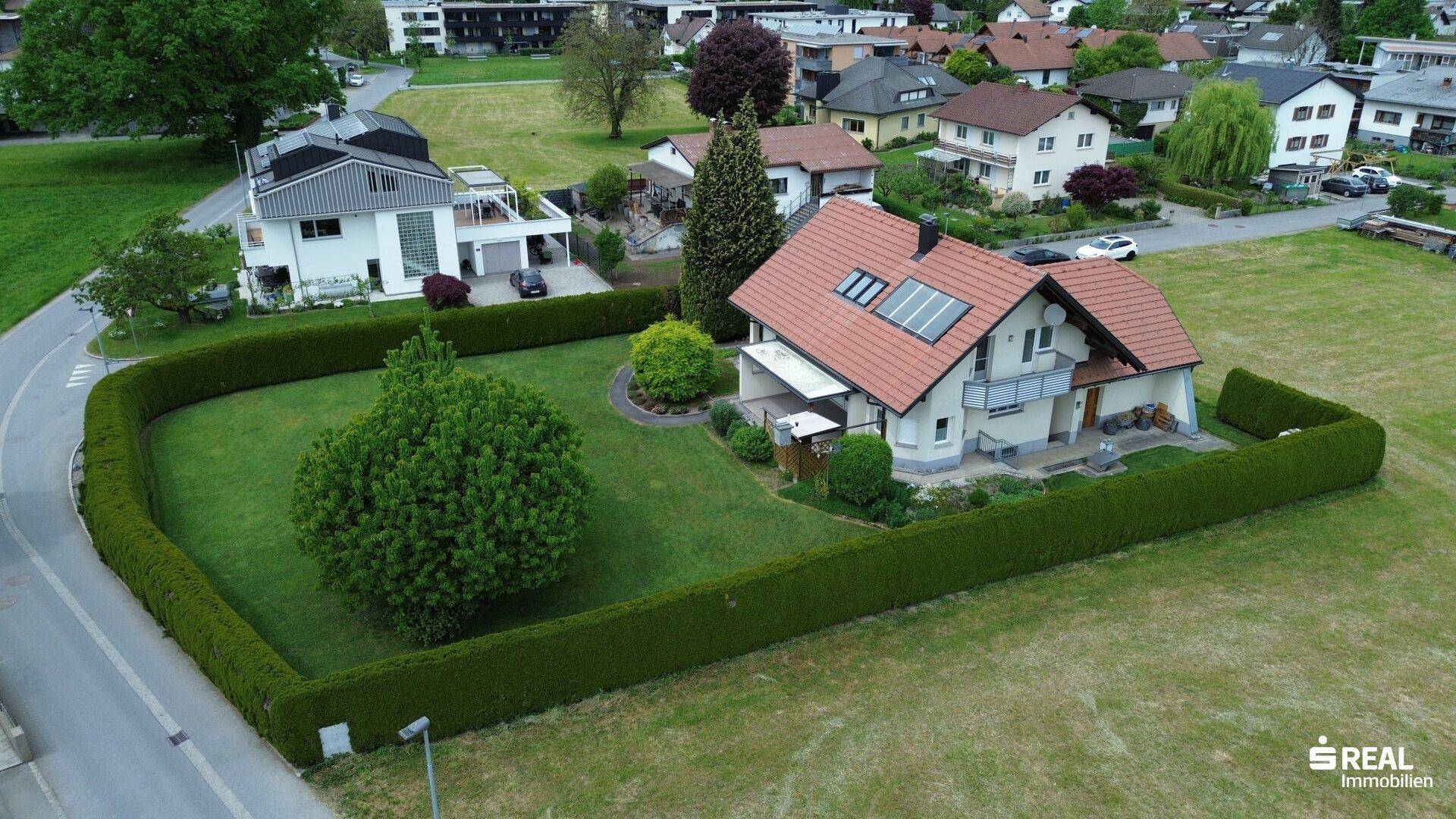 Luftaufnahme des Einfamilienhauses mit großem, gepflegtem Garten und umgebender Wohnsiedlung.