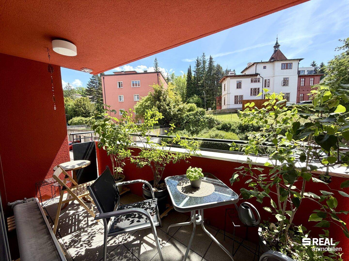 Sonniger Balkon mit Pflanzen, Sitzgelegenheiten und einem schönen Blick auf die Umgebung.