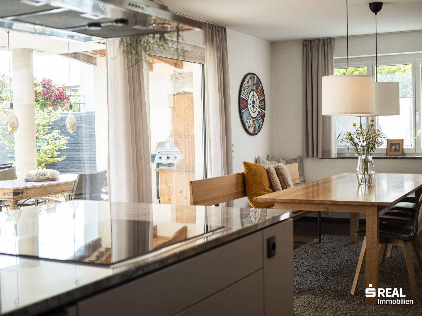 Offener Küchen- und Essbereich mit Blick auf die Terrasse und den Grill im Freien.
