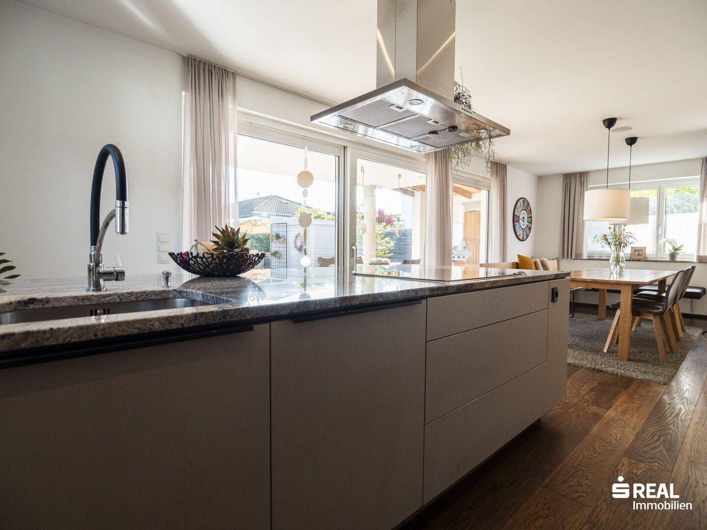 Geräumige Küche mit Kücheninsel, Granitarbeitsplatte und offenem Übergang zum Essbereich.