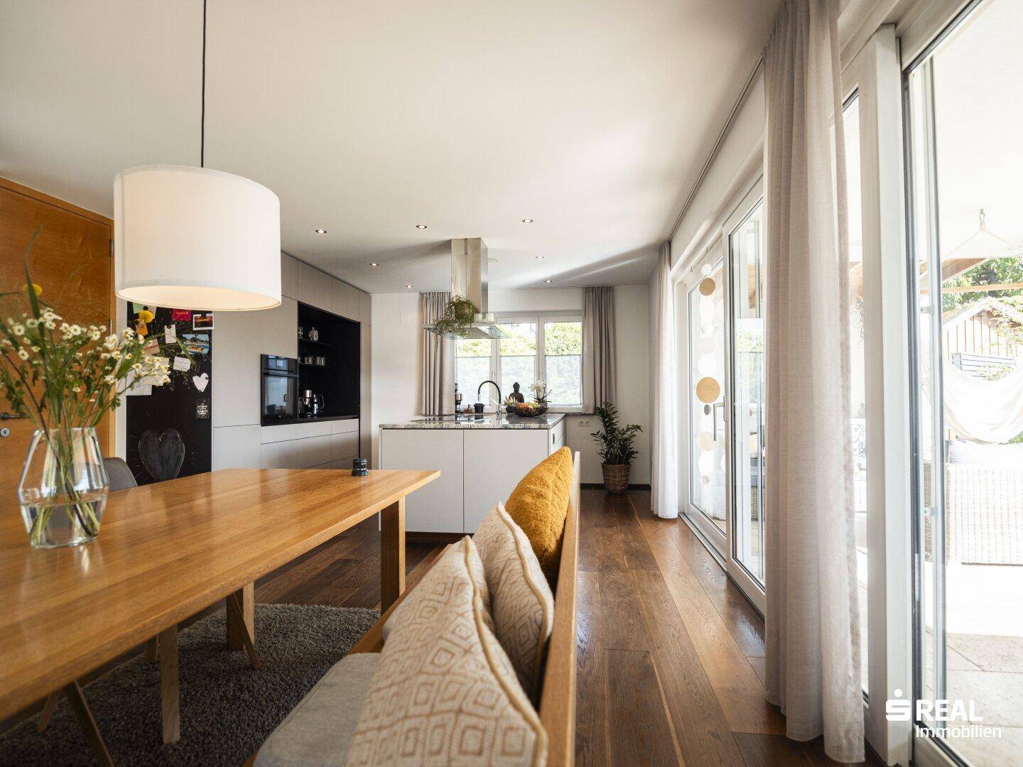 Gemütliches Wohnzimmer mit großem Sofa, Kamin und Holzboden.