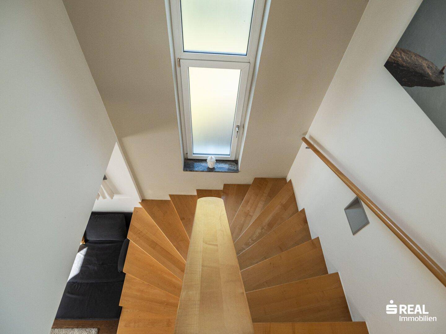 Holztreppe mit Oberlicht, die die verschiedenen Ebenen des Hauses verbindet.
