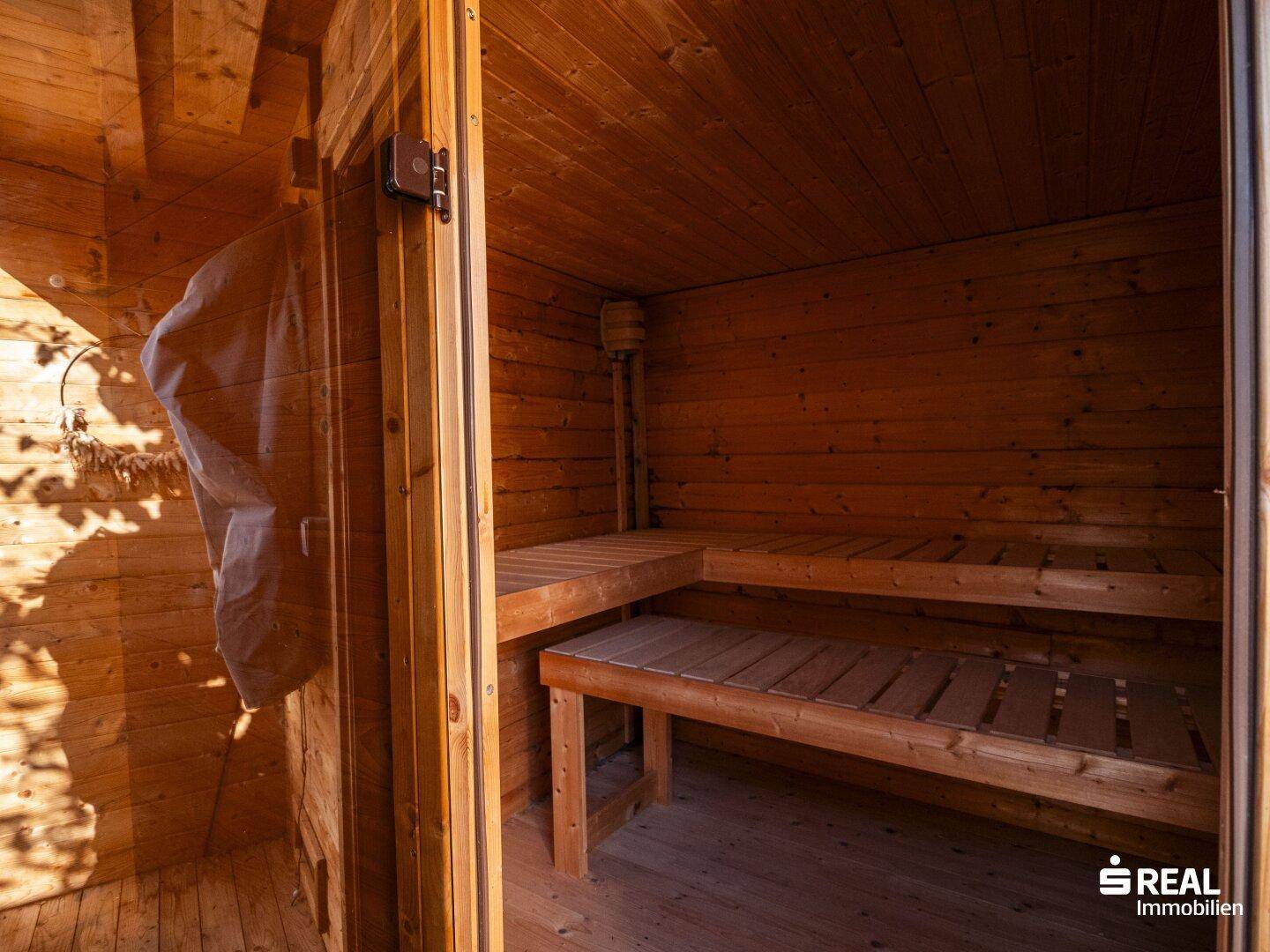 Gemütliche Holzsauna mit zwei Bänken für entspannende Momente im eigenen Zuhause.