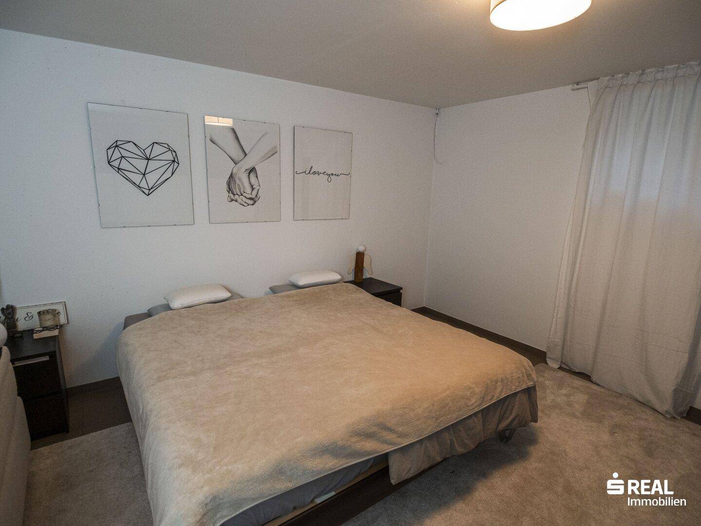 Gemütliches Schlafzimmer mit Doppelbett, Teppichboden und moderner Wanddekoration.
