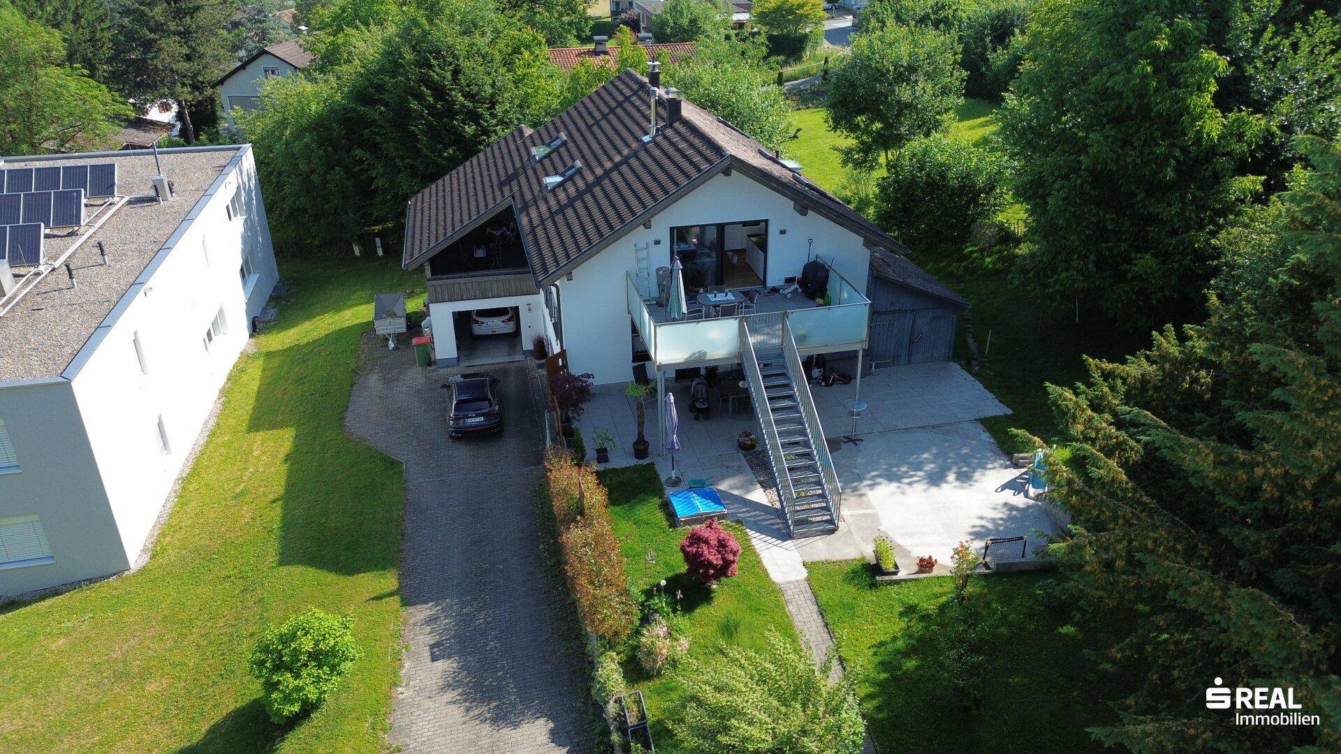 Weitläufige Luftaufnahme des Hauses mit angrenzendem Gebäude und Photovoltaikanlage auf dem Dach.