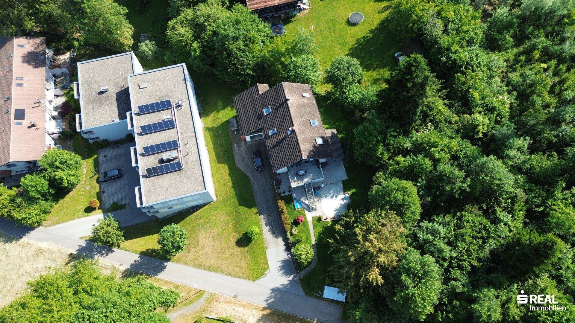 Vogelperspektive des Anwesens mit umliegenden Häusern und viel Grünfläche.