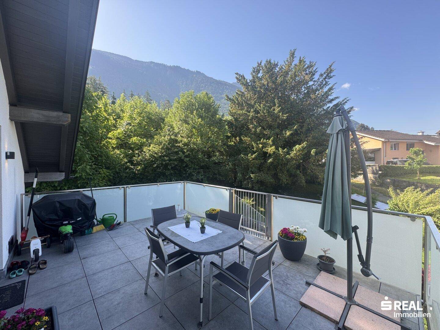 Geräumiger Balkon mit Sitzgelegenheiten und Blick auf die umliegenden grünen Hügel.