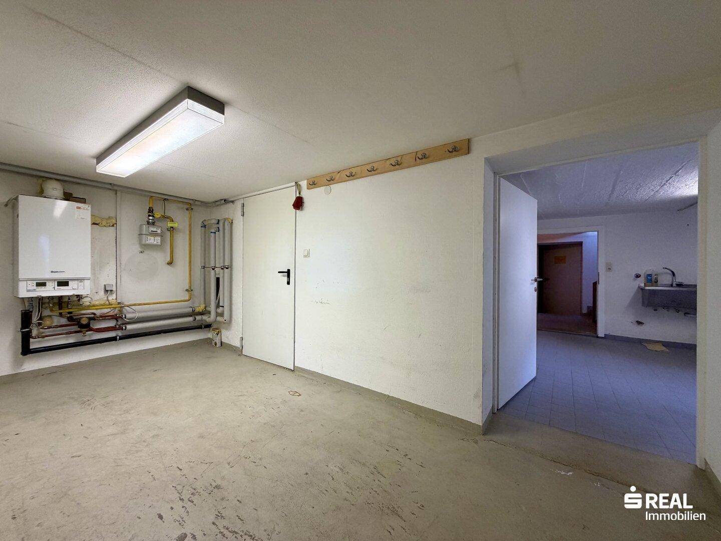Geräumiger Hauswirtschaftsraum im Keller mit Heizungsanlage und Waschbecken.