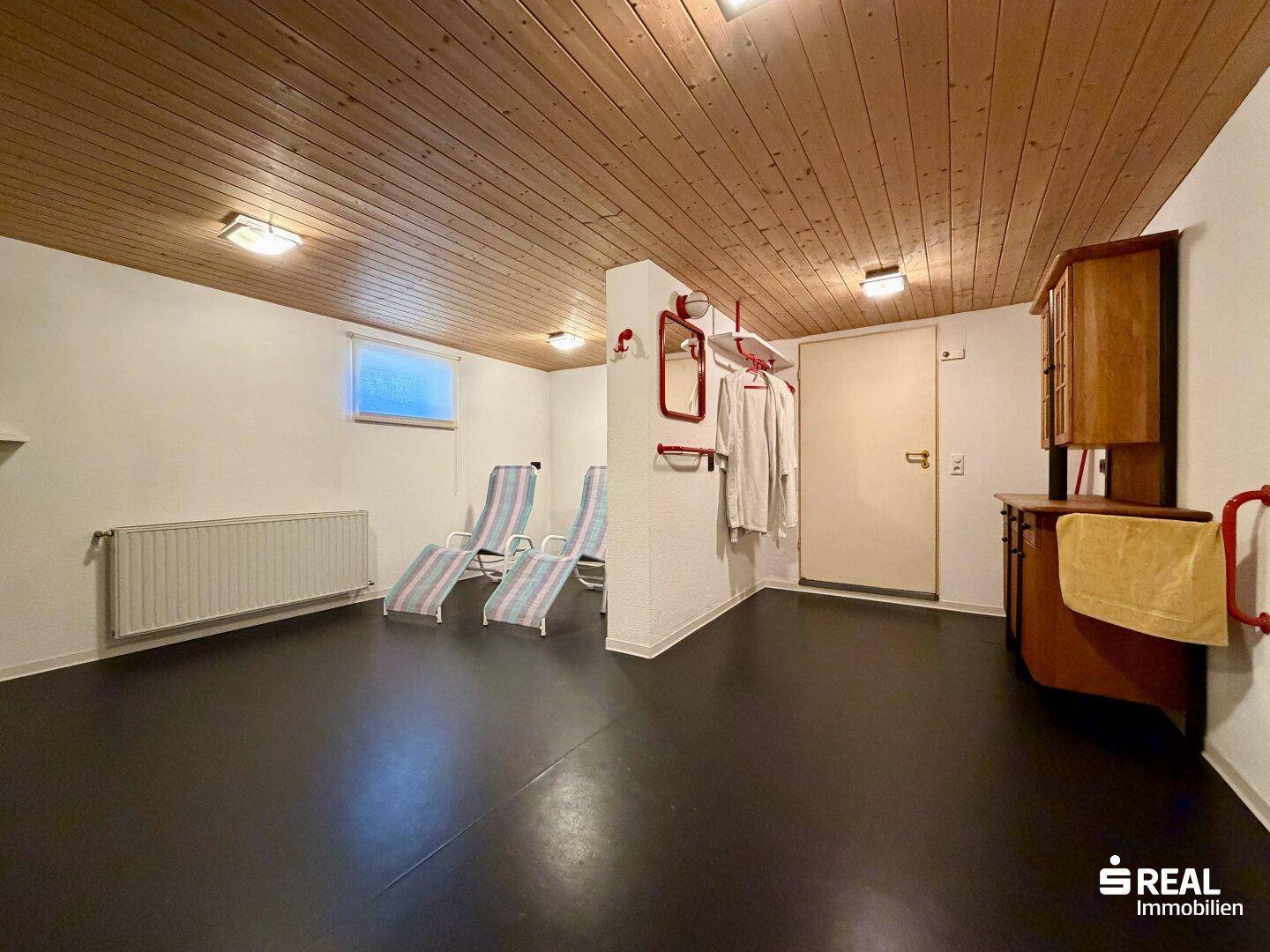 Gemütlicher Ruheraum im Keller mit Holzdecke und Liegestühlen, ideal zur Entspannung.
