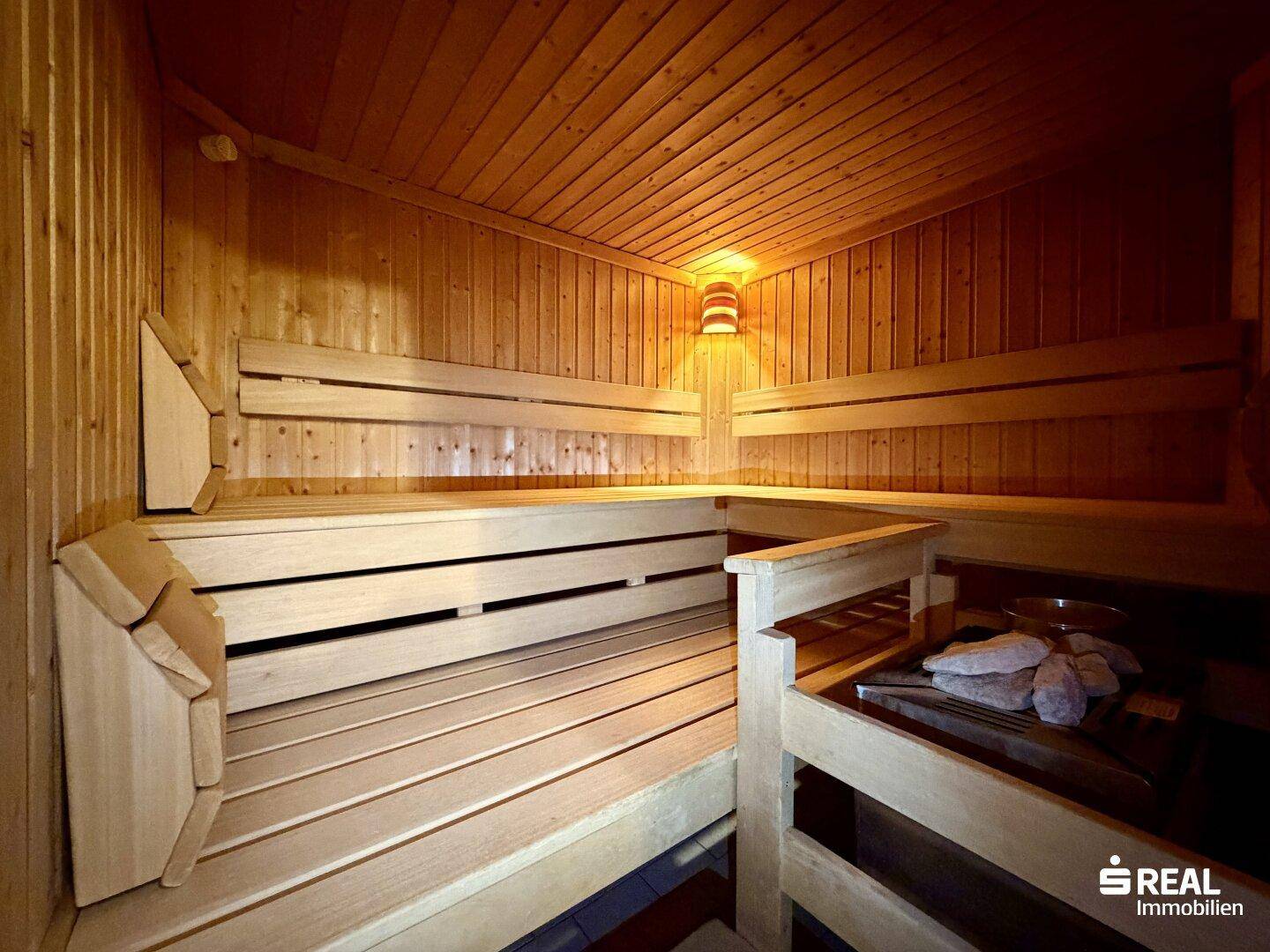 Traditionelle Holzsauna mit mehreren Bänken und Saunaofen für entspannende Momente.